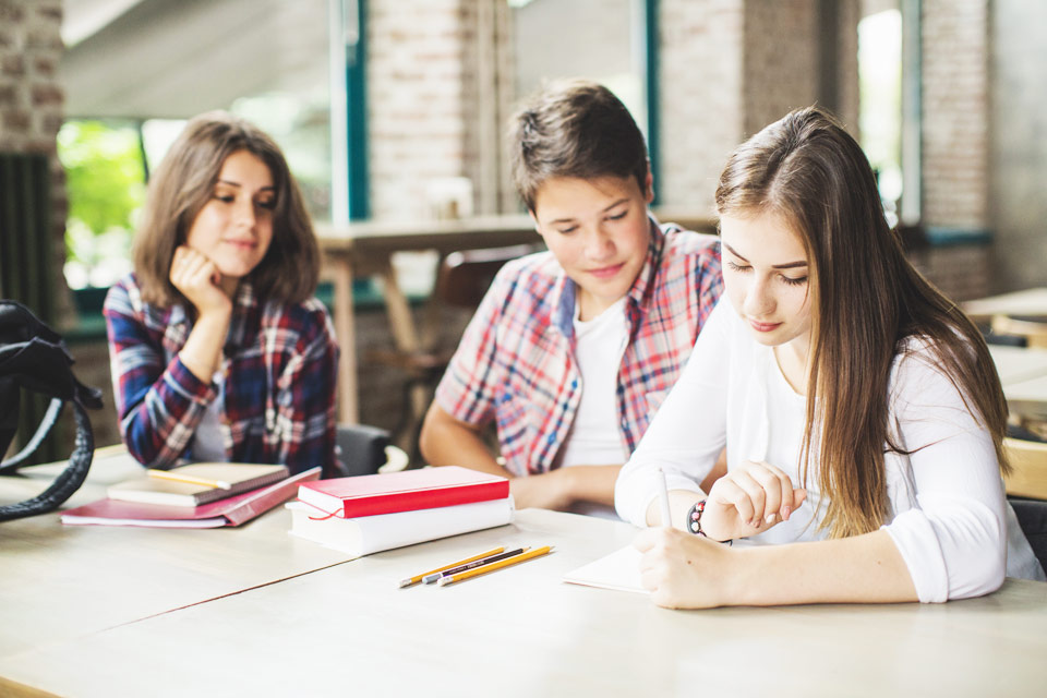 Studenti u stolu s učebnicemi a sešity